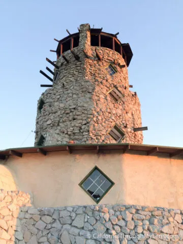 Historic stone tower on a hill with desert views in the background