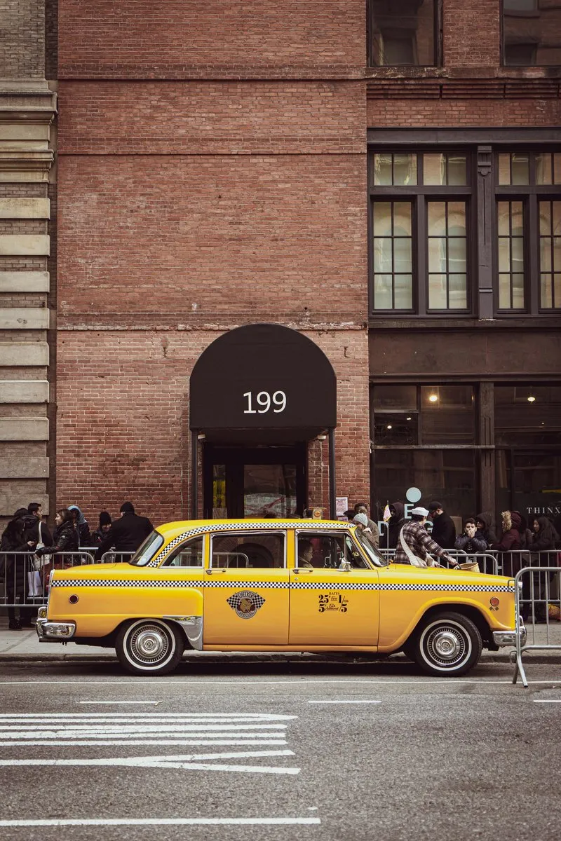 Historical image of a red and green taxi cab in New York City, before the mandatory yellow color