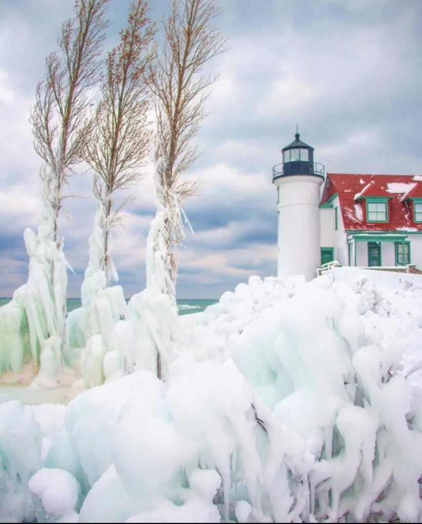 Ice-covered lighthouse on a snowy Michigan lakeshore during winter
