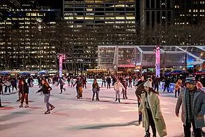 Ice skaters glide on the rink at the Bank of America Winter Village at Bryant Park, a popular spot for what to do in NYC in December.
