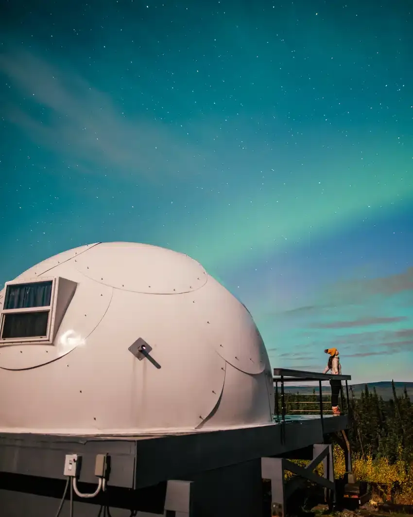 Igloo with northern lights visible through the roof in Fairbanks, Alaska