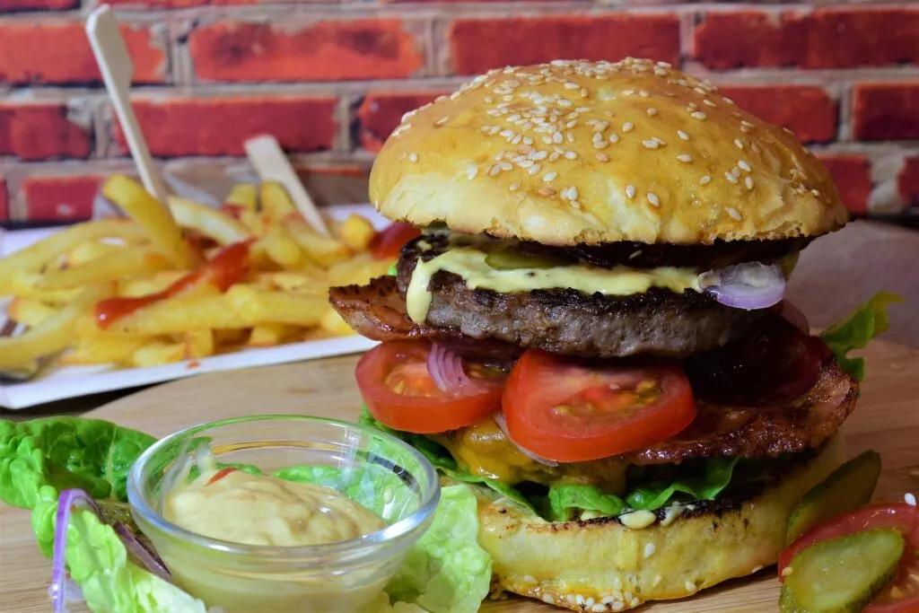 Exploring the Phenomenon of True Texas BBQ Juicy Texas-sized cheeseburger with fries, a popular item when considering what to eat in Texas.