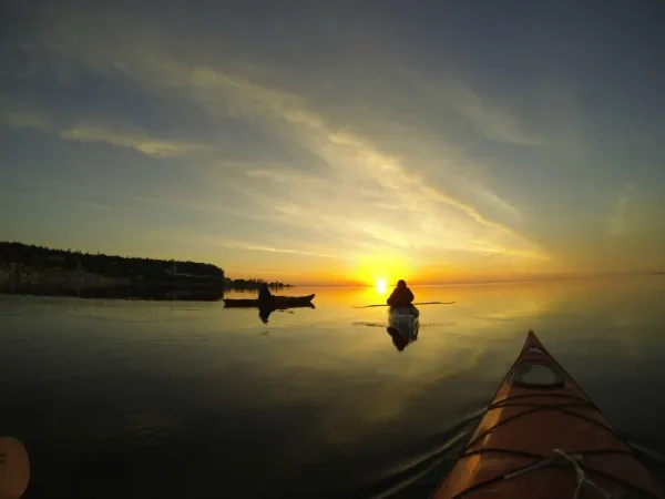 Kayakers paddling near the shore of Mackinac Island, a popular and unique way to explore this historic Michigan destination.