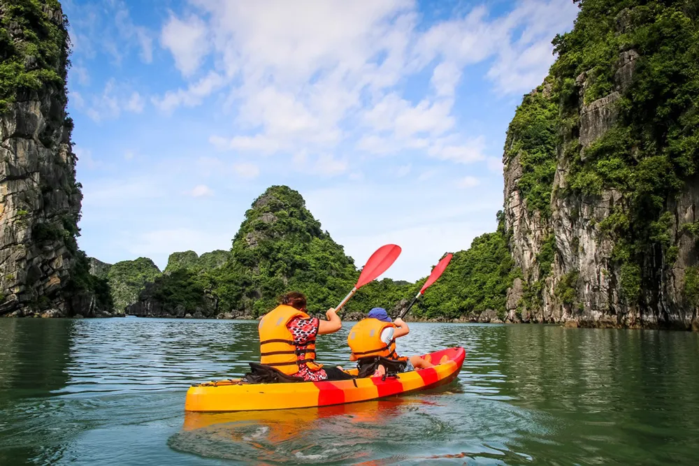 Kayaking among the limestone karsts in Halong Bay, a fun way to explore hidden areas