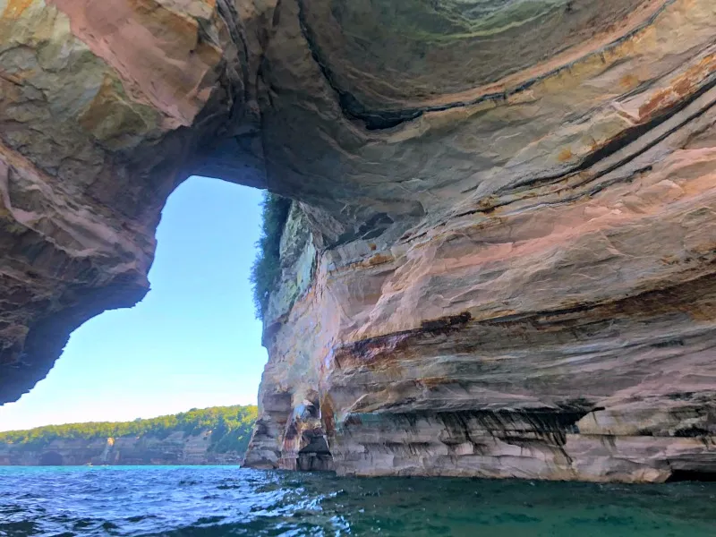 Kayaking through an archway along the stunning Pictured Rocks National Lakeshore, a highlight when you explore the Upper Peninsula's coast by water.