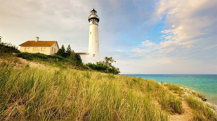Lighthouse on South Manitou Island with sand dunes and lake in the background at Sleeping Bear Dunes National Lakeshore