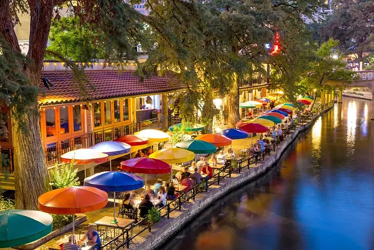 Lush riverwalk lined with restaurants, a popular texas sight in San Antonio