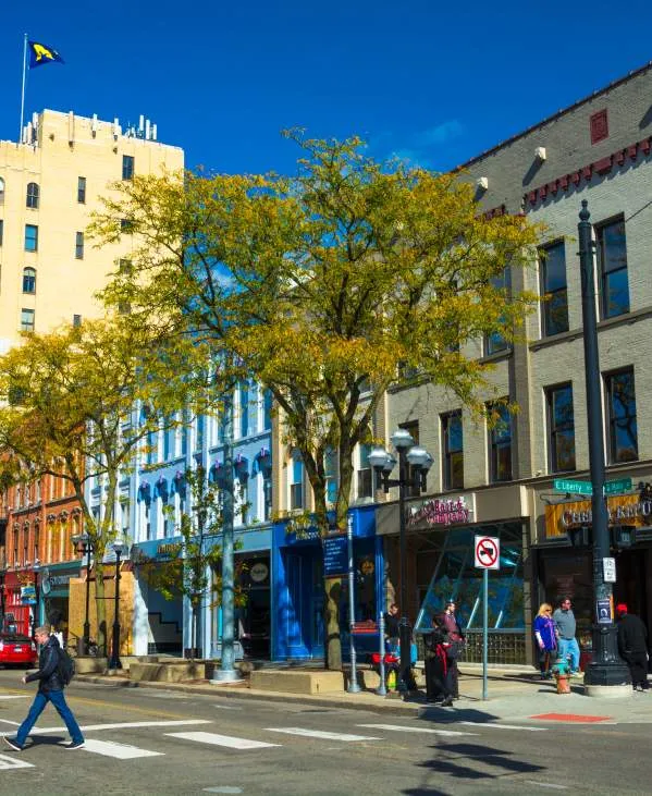 Man crossing Main Street in downtown Ann Arbor