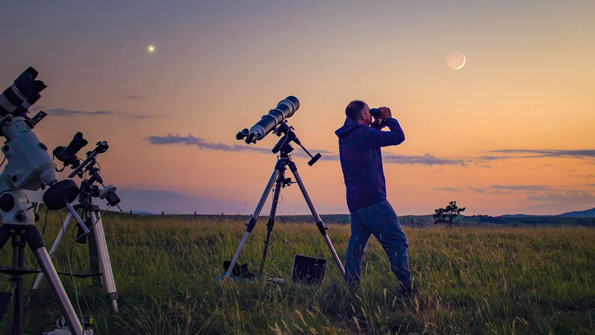 Man observing the night sky with a good backyard telescope setup