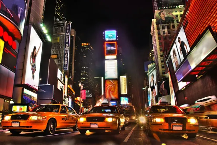 Massive, illuminated billboards and screens in Times Square at night, capturing the energy of this famous place in New York