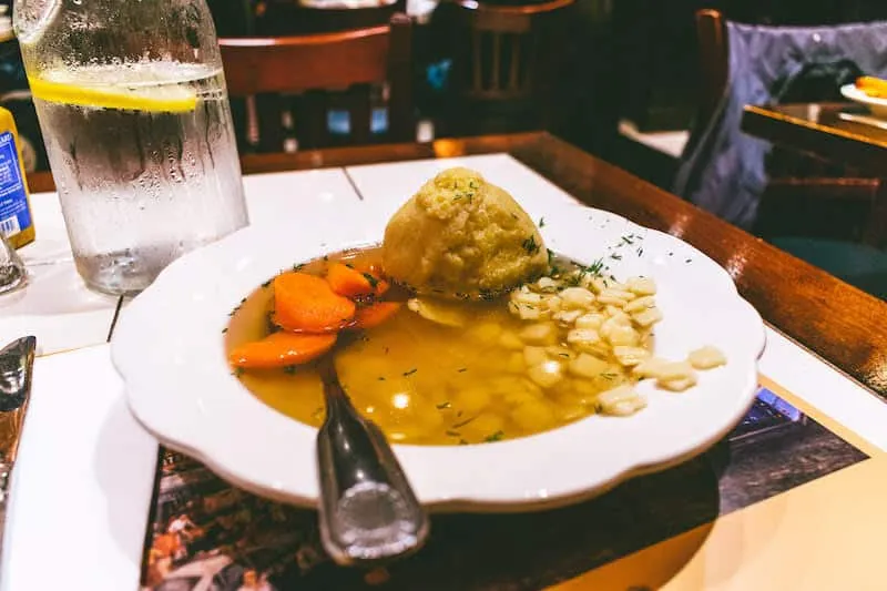 Matzo ball soup and pickles at the 2nd Avenue Deli, a classic Jewish deli among famous places to eat in New York