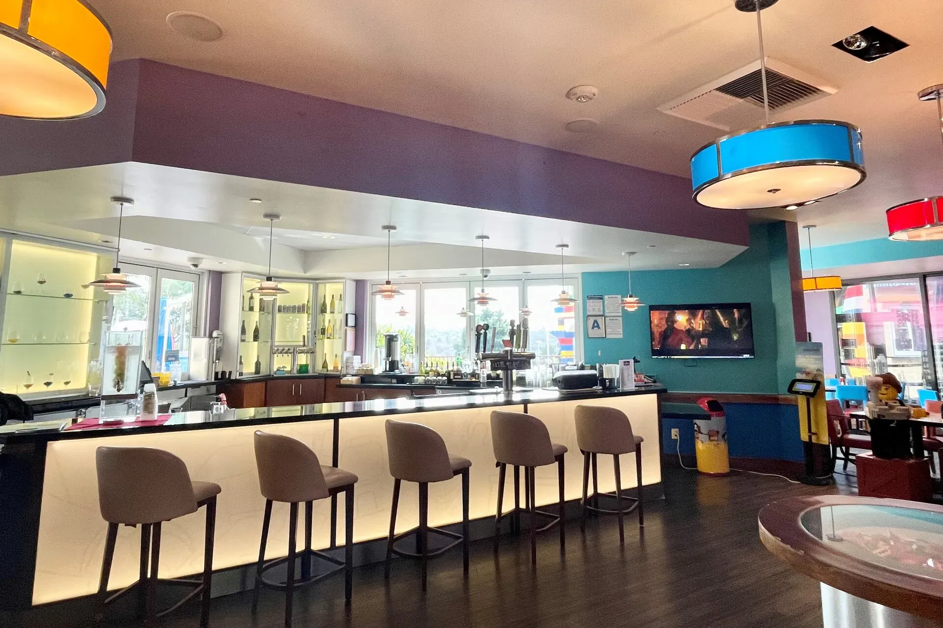 Modern cafe seating area with a view of a cityscape mural.