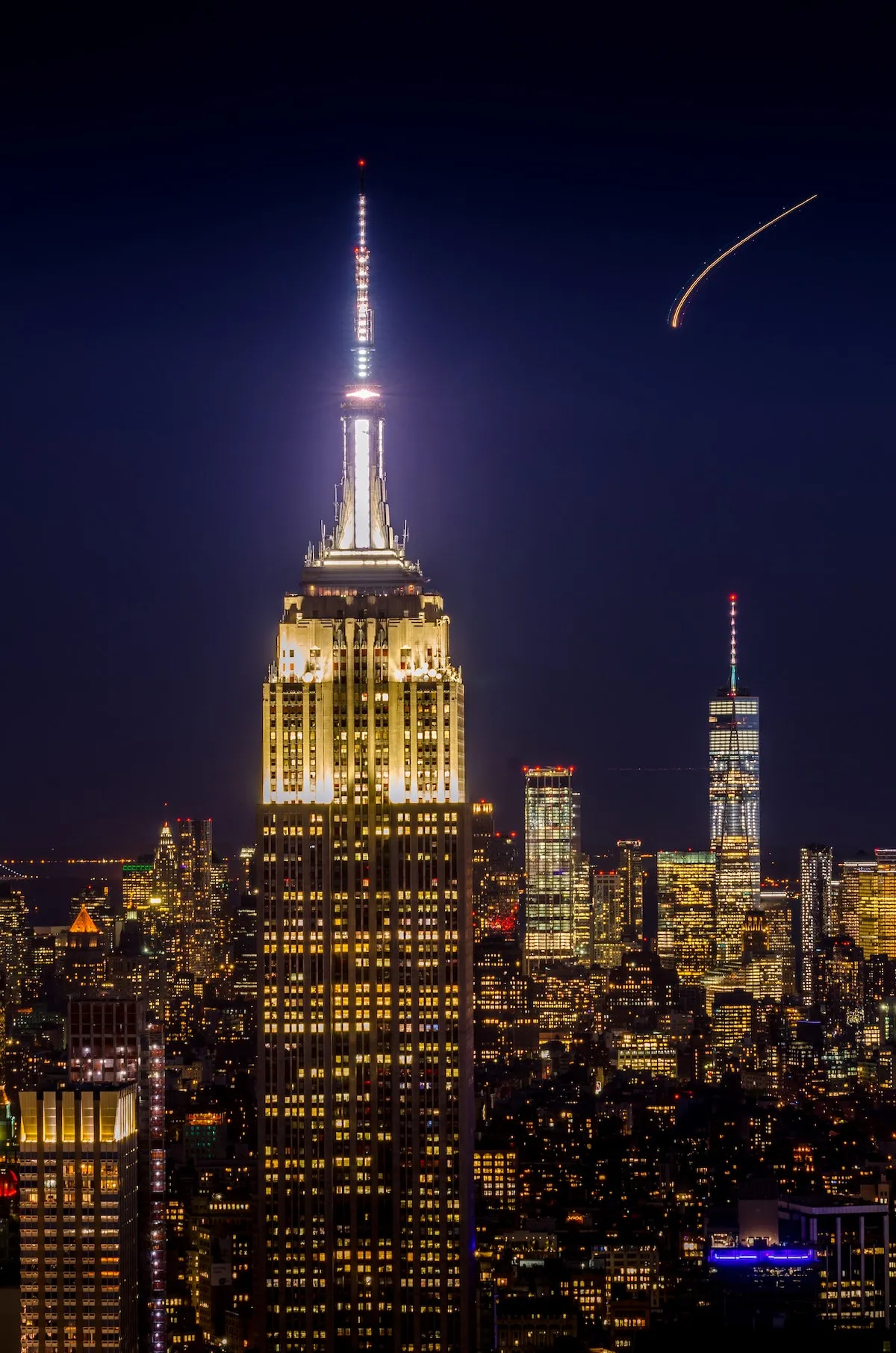 New York City skyline lit up at night, showcasing the energy of going out in new york.