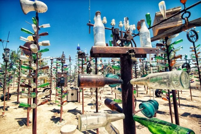 Numerous metal poles decorated with colorful glass bottles (Bottletree Ranch)