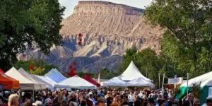 Overlooking a crowd of people and tents with the moutains in background at the Colorado Mountain Winefest