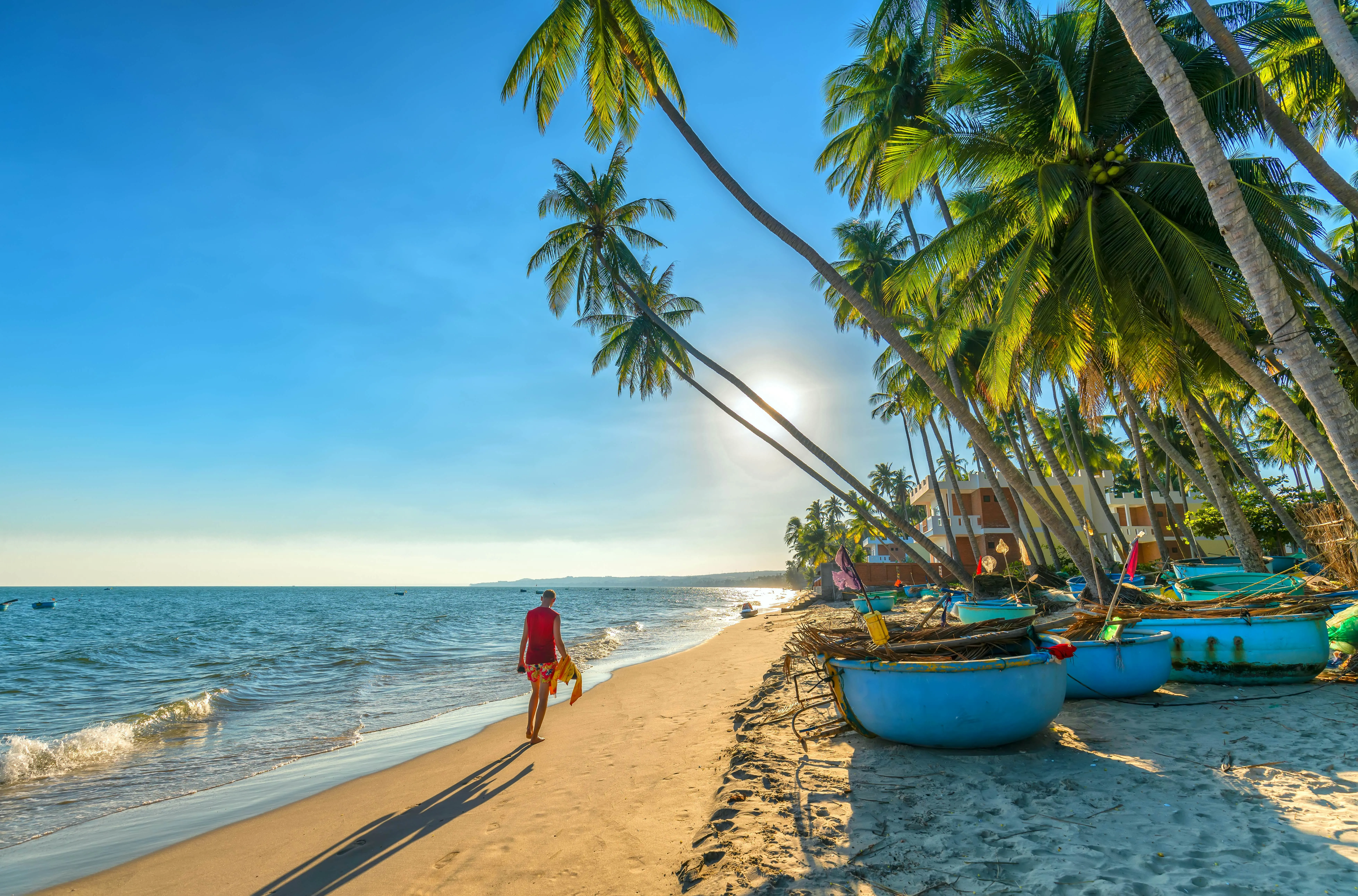 Palm trees line a sandy beach in Mui Ne, offering ideal weather when planning When To Travel To Vietnam.