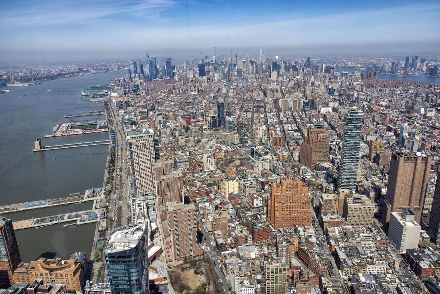 Panoramic view from One World Observatory showing Lower Manhattan, the harbor, and bridges