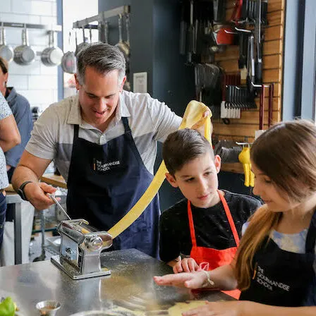 Parent and child cooking together in a fun culinary class setting in Los Angeles