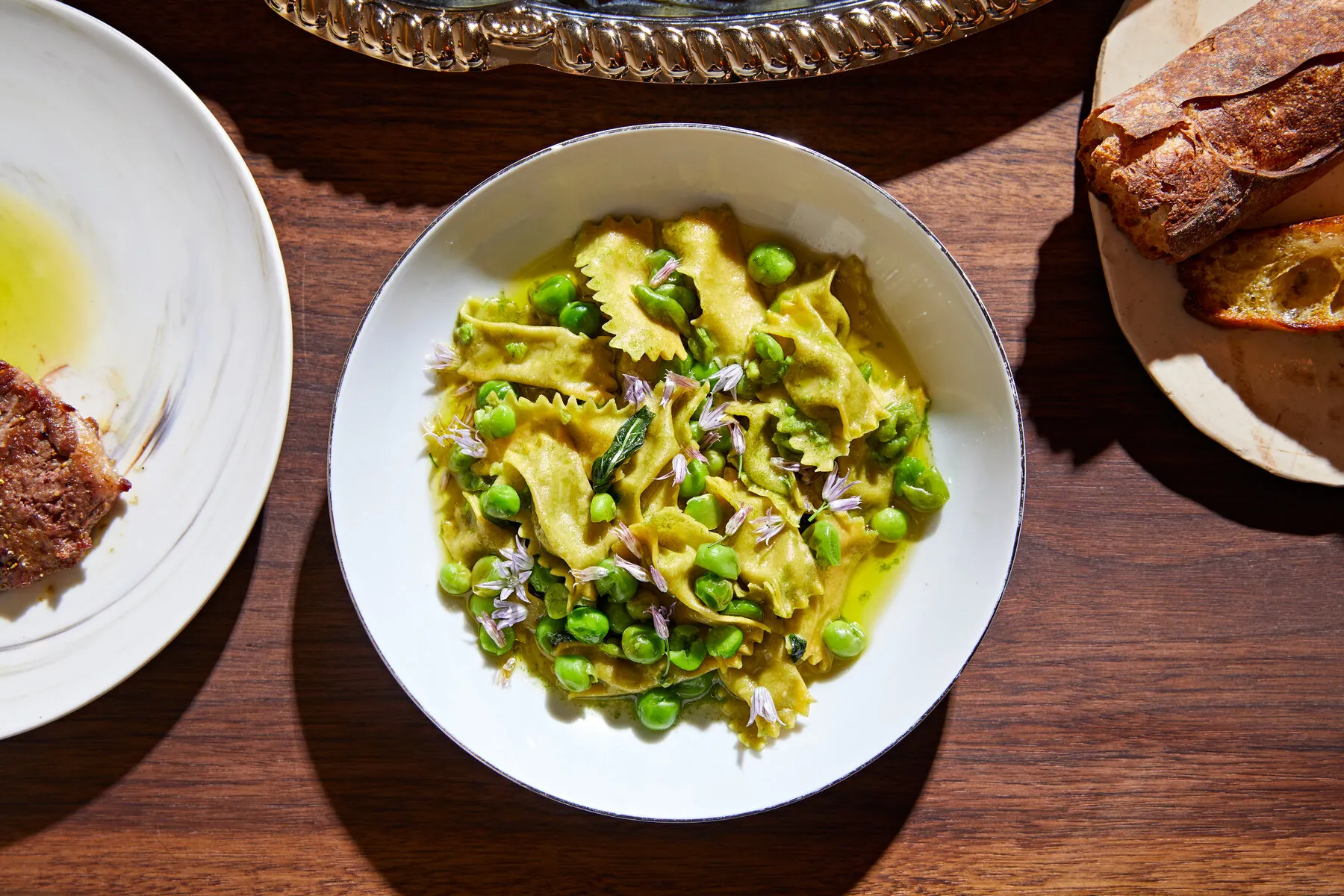 Pasta parcels filled with green peas and chive blossoms at Foul Witch, indicating the restaurant's focus on creative Italian dishes.