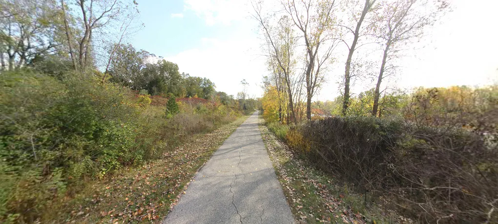 Paved trail running near a body of water, characteristic of the Freedom Metro Trail