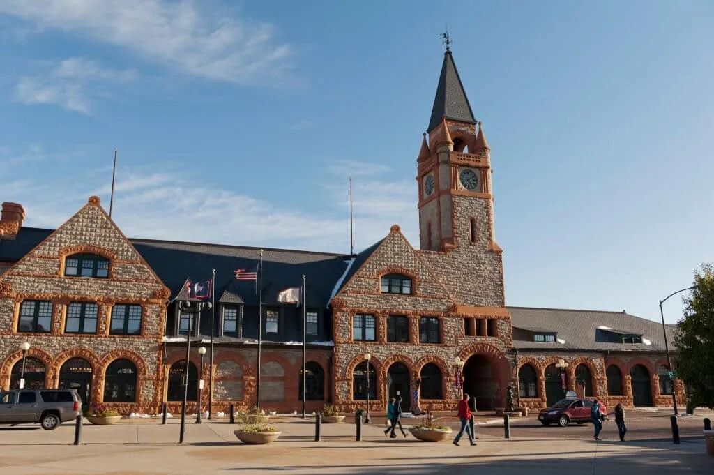 People and cars in front of the historic Cheyenne Depot Museum building - Transportation History Things To See And Do In Wyoming