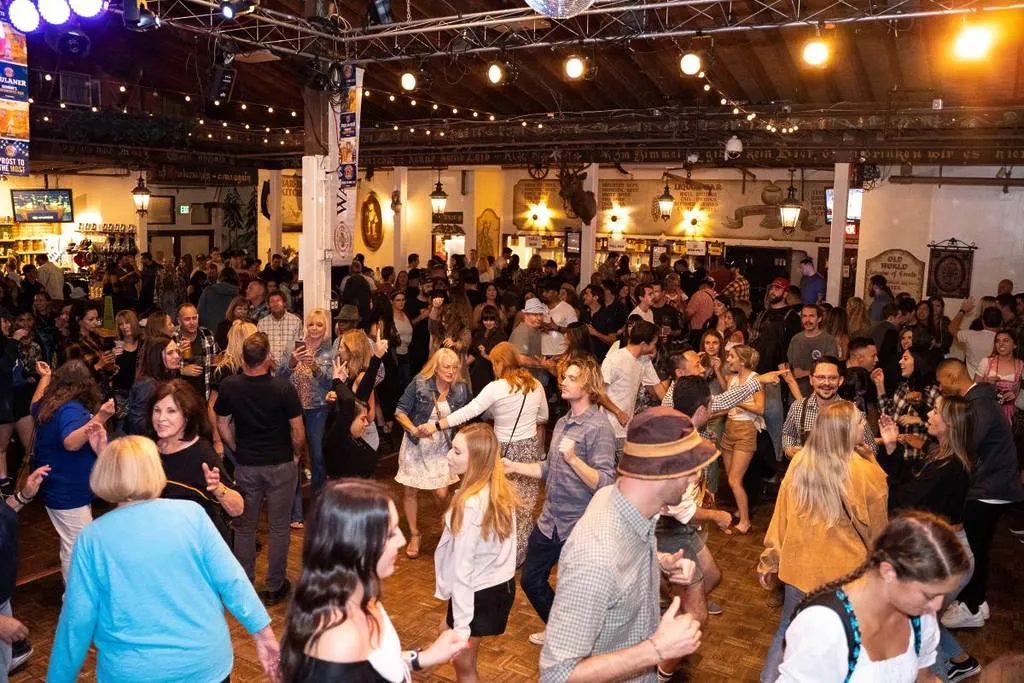 People dancing and celebrating at a bustling Oktoberfest event in Los Angeles area