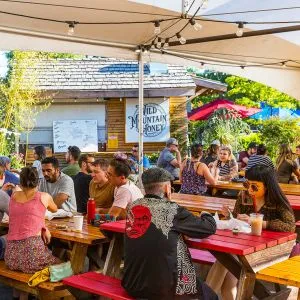 People eating at tables at a food cart pod on Hawthorne Boulevard