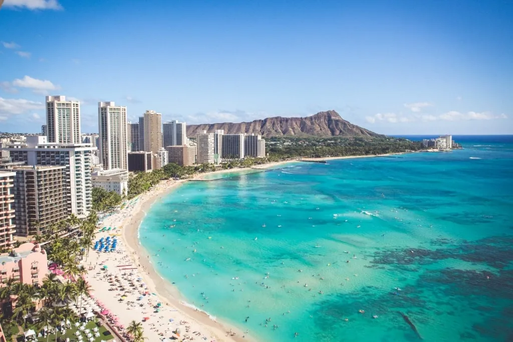 People enjoying the waves and sand at Waikīkī Beach, a world-famous Best Beach In Honolulu option