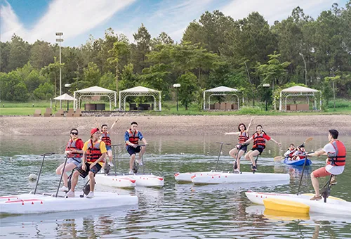 People enjoying water activities like kayaking and paddle boating on a lake