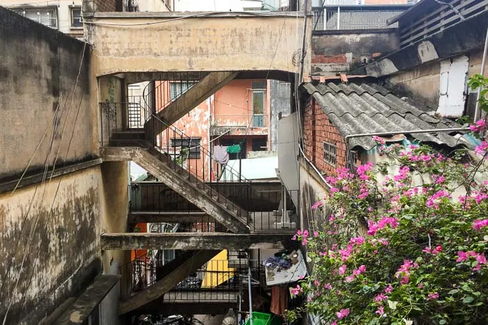 People walking through a hallway inside the old apartment building at 14 Ton That Dam
