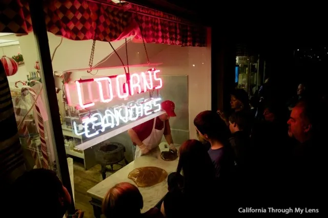 People watching a demonstration of candy canes being made by hand