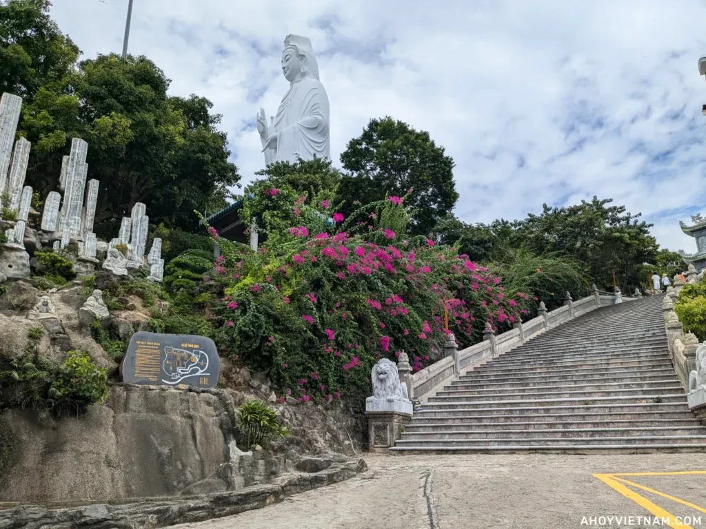 Pink flowers and a staircase leading to Lady Buddha in Da Nang, Vietnam.