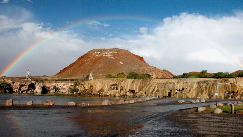Rainbow over a rock formation and sign at Hot Springs State Park in Thermopolis - Natural Things To See And Do In Wyoming
