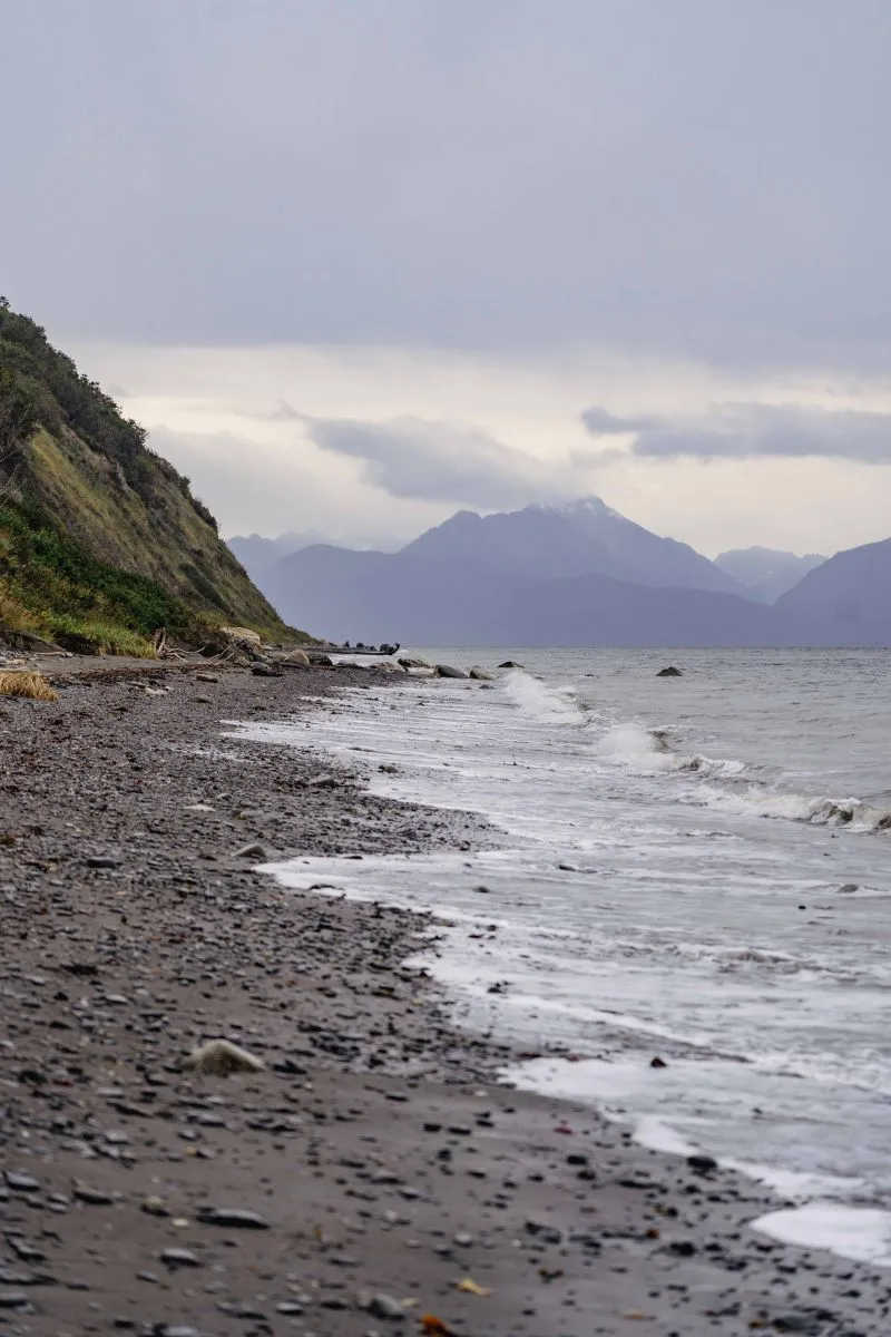 Rocky beach at Cook Inlet with snow-capped mountains in Homer, Alaska