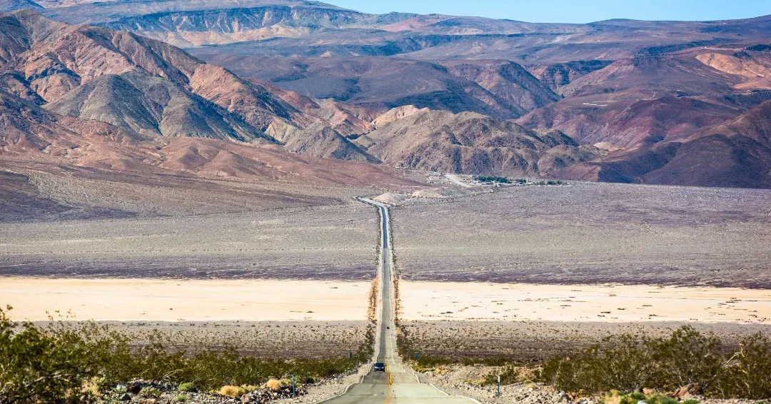 Rolling sand dunes under a clear sky in Death Valley National Park