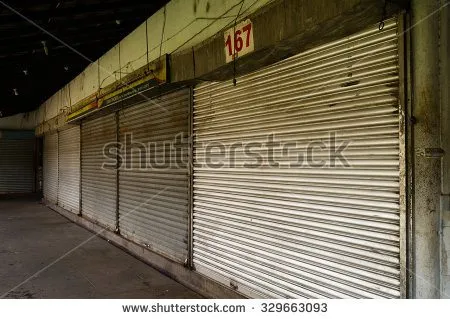 Row of shops with metal doors closed at night