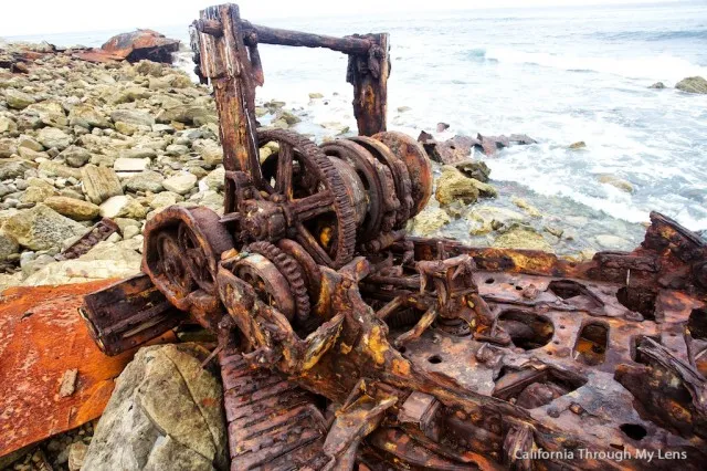 Rusted wreckage of a ship scattered on a rocky beach