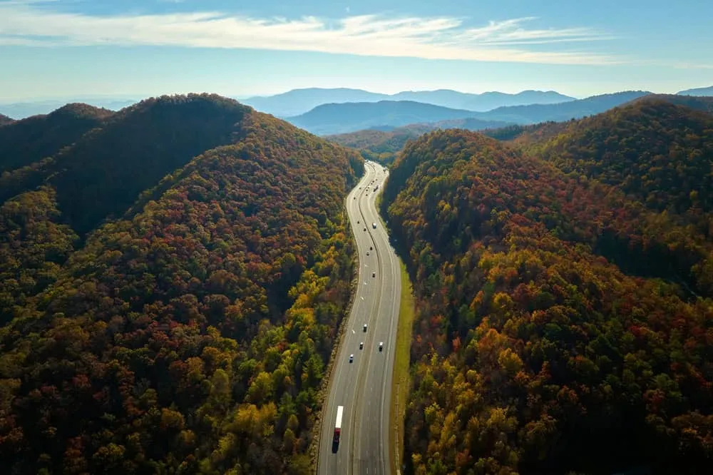 Scenic winding road through mountains with early fall foliage near Asheville