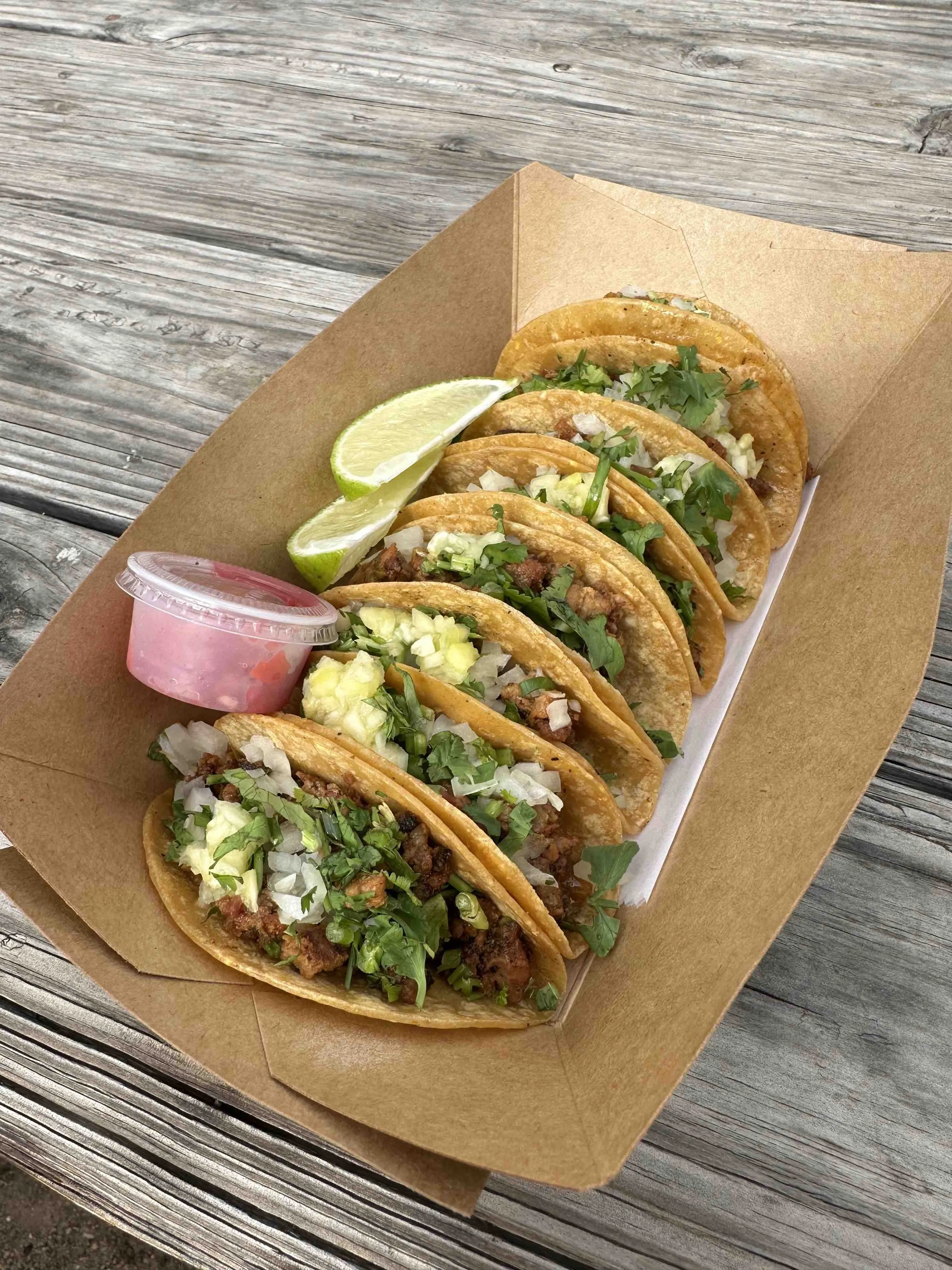 Several small discada tacos with meat and pineapple on a plate, characteristic of Discada in Austin