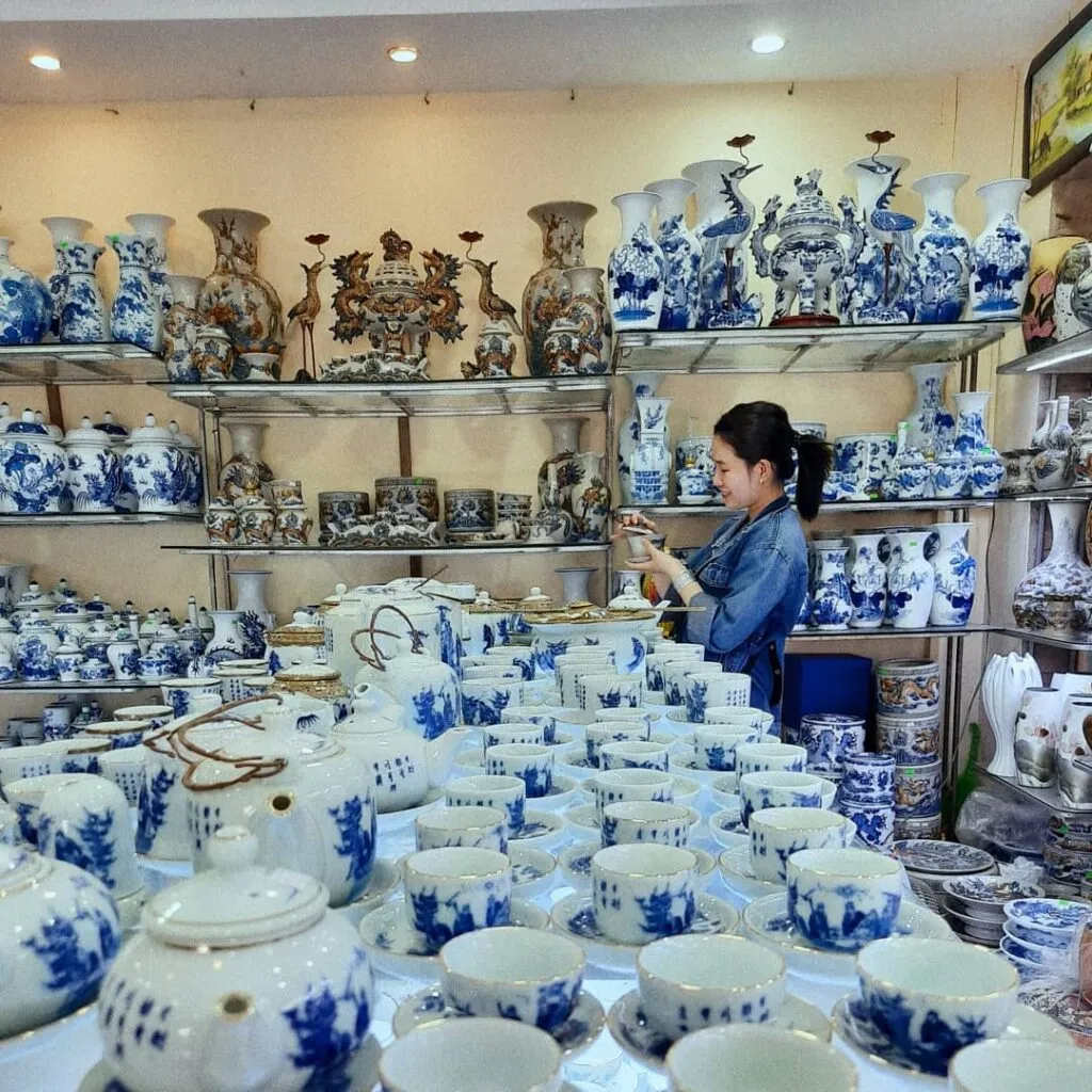 Shoppers browsing through stacks of pottery in a ceramic shop