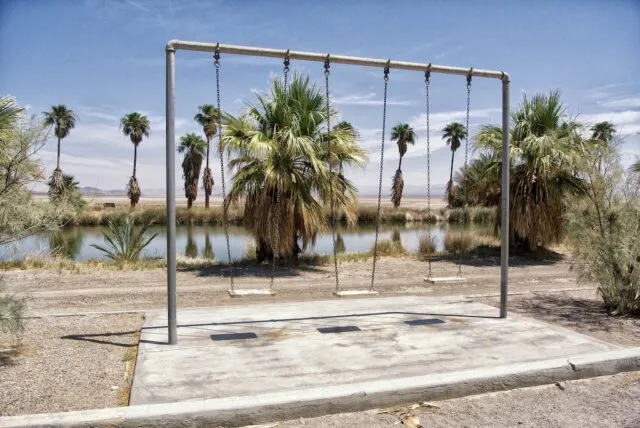 Sign for Zzyzx Road with a desert landscape