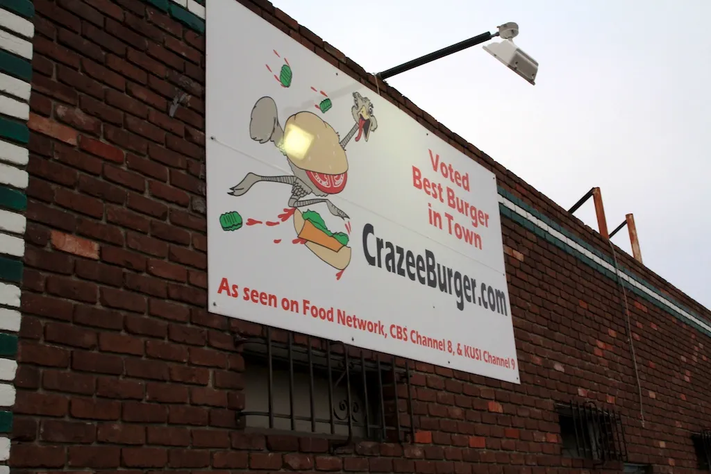 Sign outside Crazee Burger restaurant advertising exotic meat options