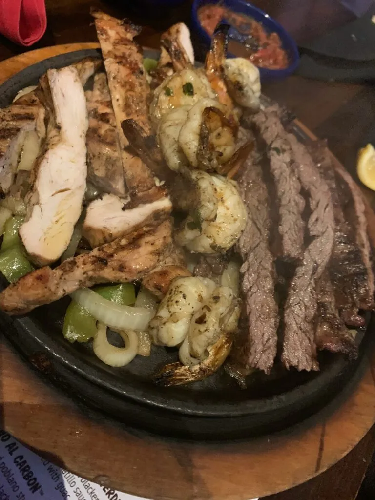 Your Ultimate Guide on where to go in Houston Texas Sizzling plate of Tex-Mex beef fajitas with onions and peppers, a classic dish to eat in Texas.