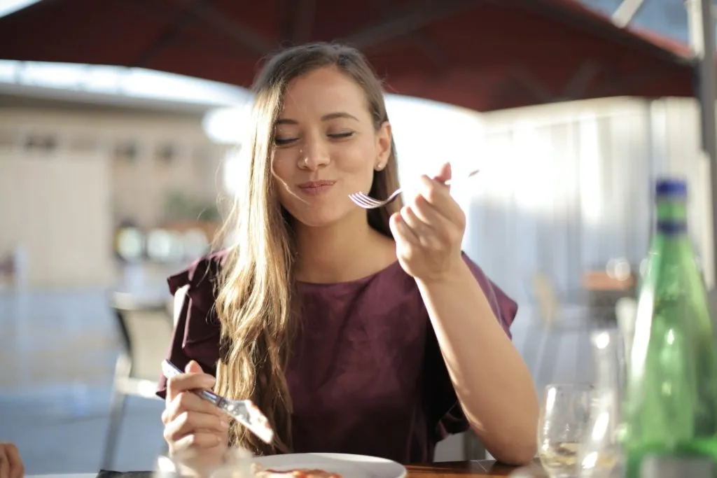 Solo traveler enjoying lunch outside, tasting local cuisine
