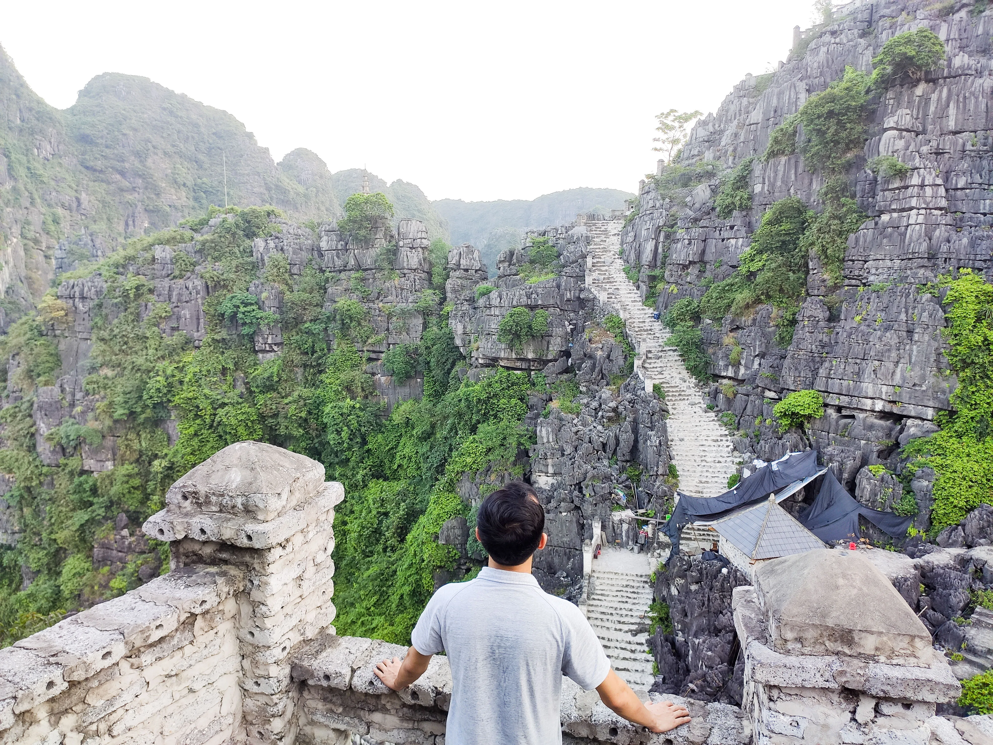 Steps winding up a limestone karst towards a viewpoint tower overlooking a valley