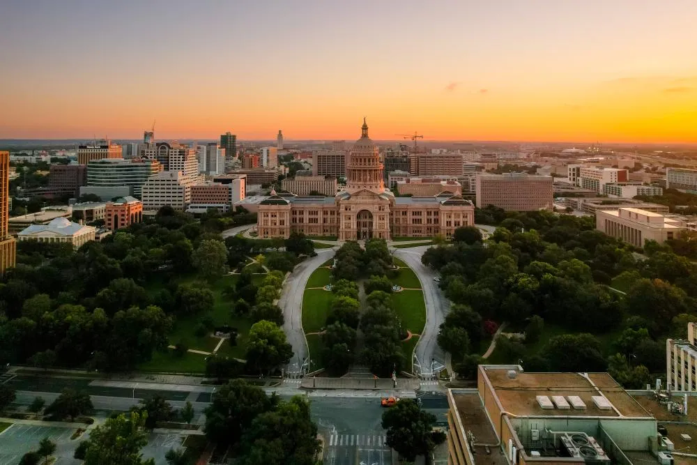Sunrise aerial view of the Texas State Capitol building and grounds in Austin.