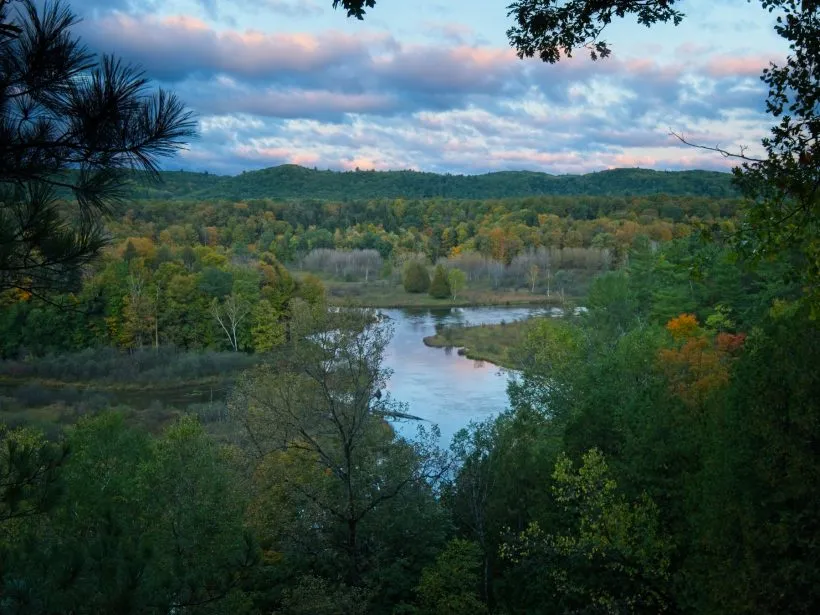 Sunrise casting a golden glow over the Manistee River valley from a campsite