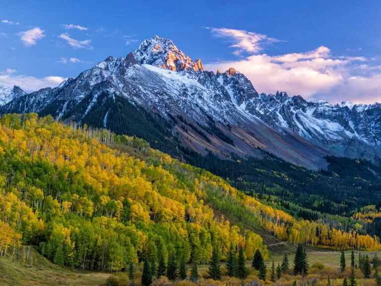 Sunset glow illuminates Mount Sneffels peaks, a romantic backdrop for honeymoon destinations colorado.