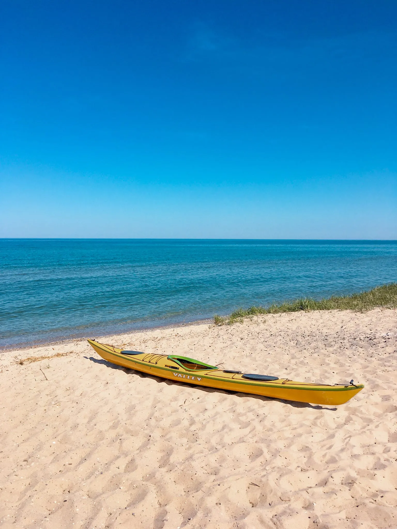 Tent set up near a sandy beach by calm water