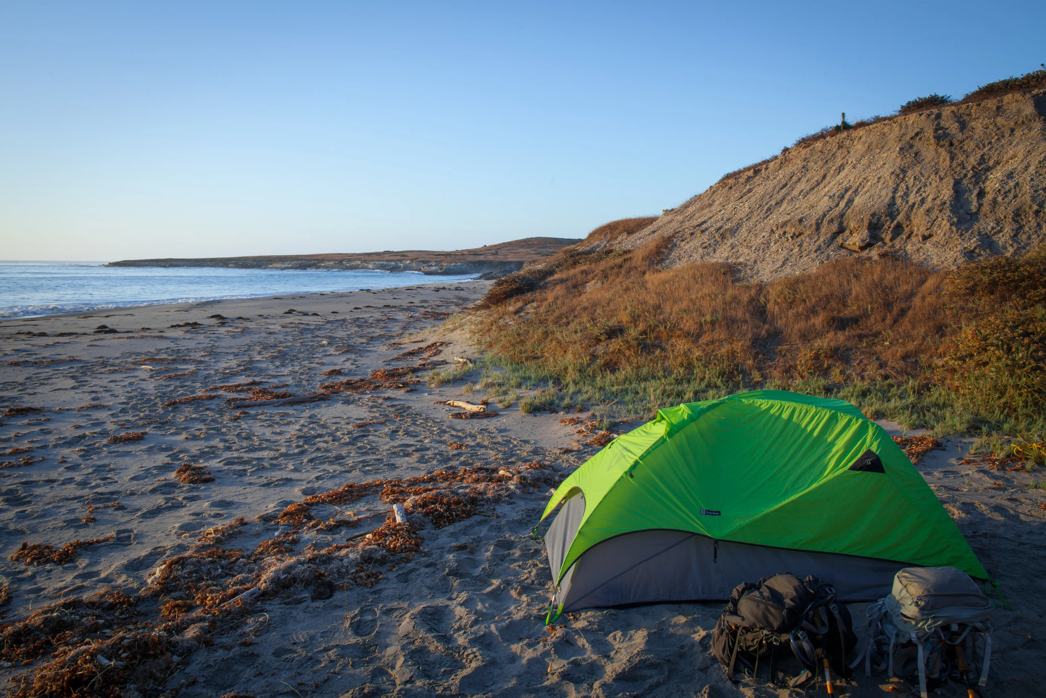 Tent set up on a beach campsite overlooking the ocean